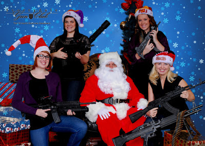 Santa Claus holding a gun with five other woman also holding guns