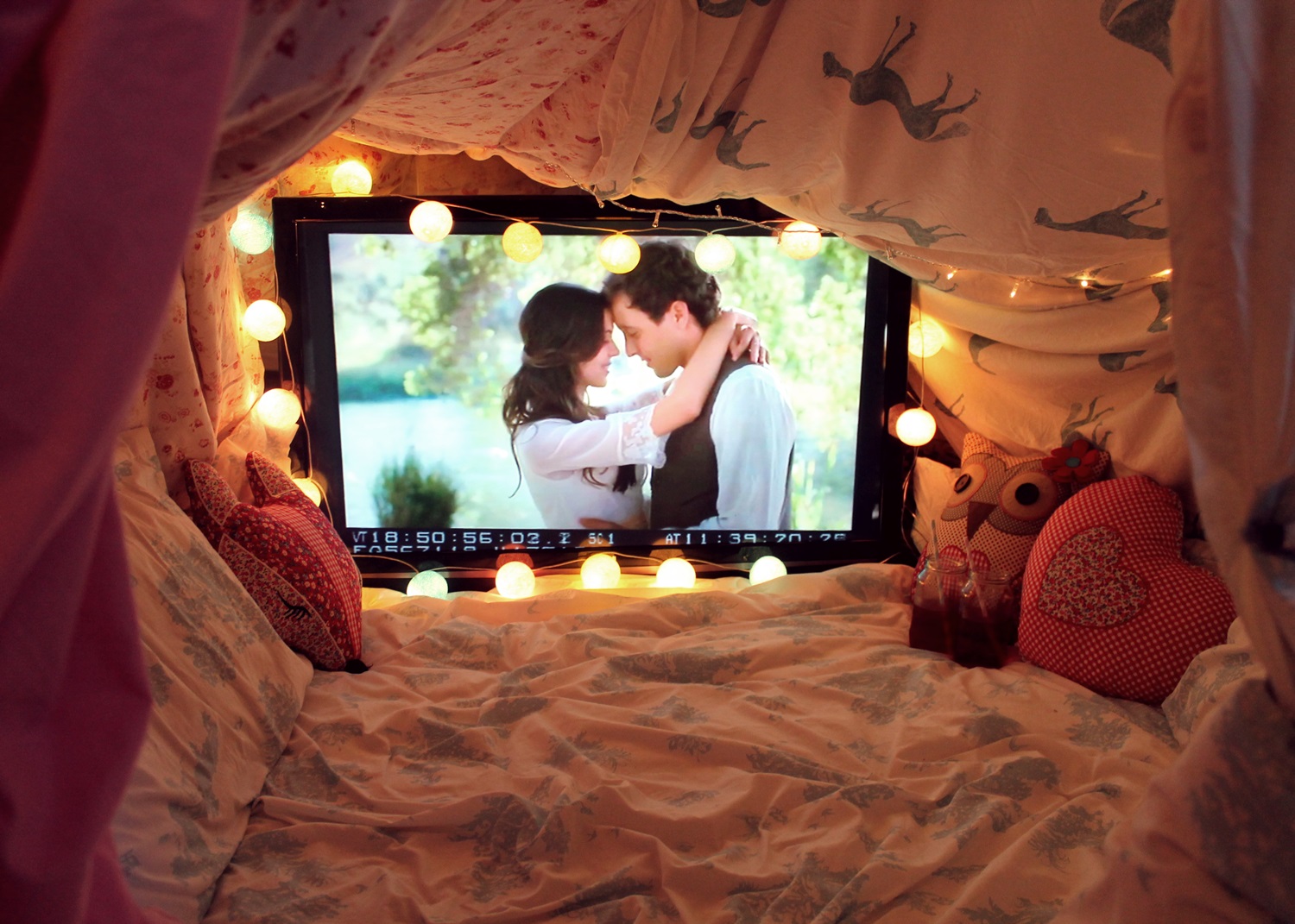 Вместе смотрят телевизор. Романтическая атмосфера в комнате. Романтик в комнате. Спальня для влюбленных. Уютная комната с телевизором.