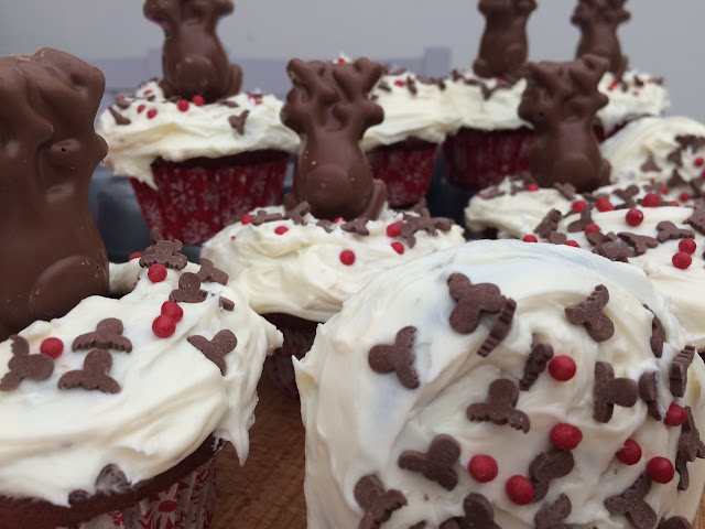 Red velvet cupcakes topped with chocolate reindeers/sprinkles