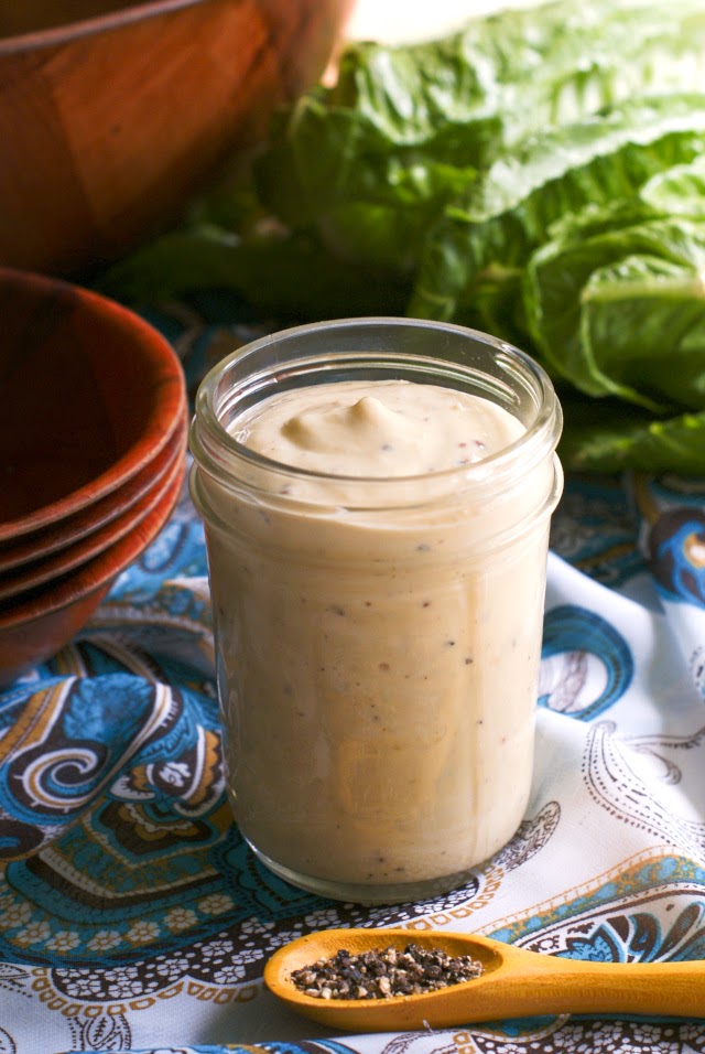 Homemade Creamy Caesar Salad Dressing in a small mason jar with a teal and white paisley background.