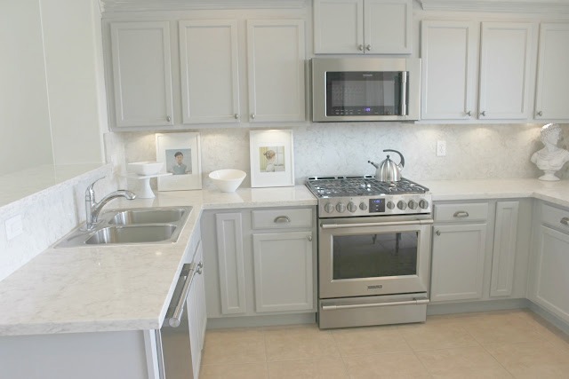 Serene chic simple Nordic French kitchen with grey cabinets and Soprano quartz countertop and backsplash