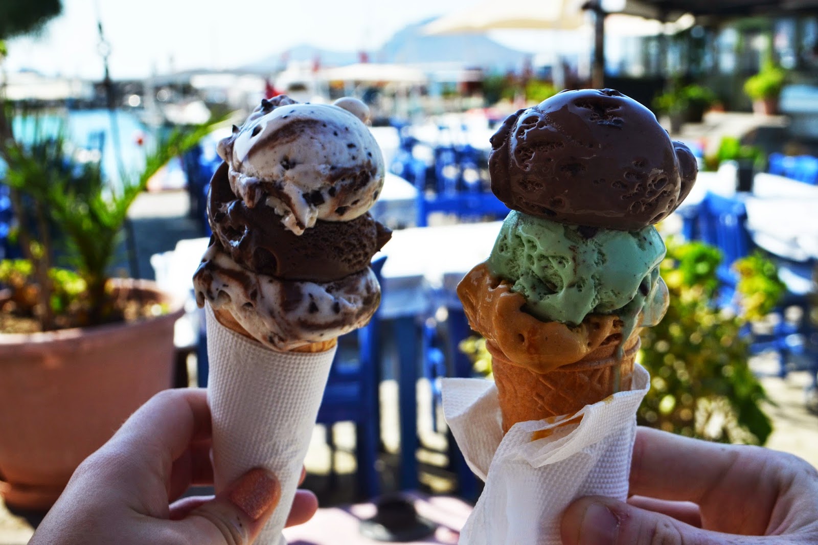 two ice cream cones filled with various scoops of icecream 