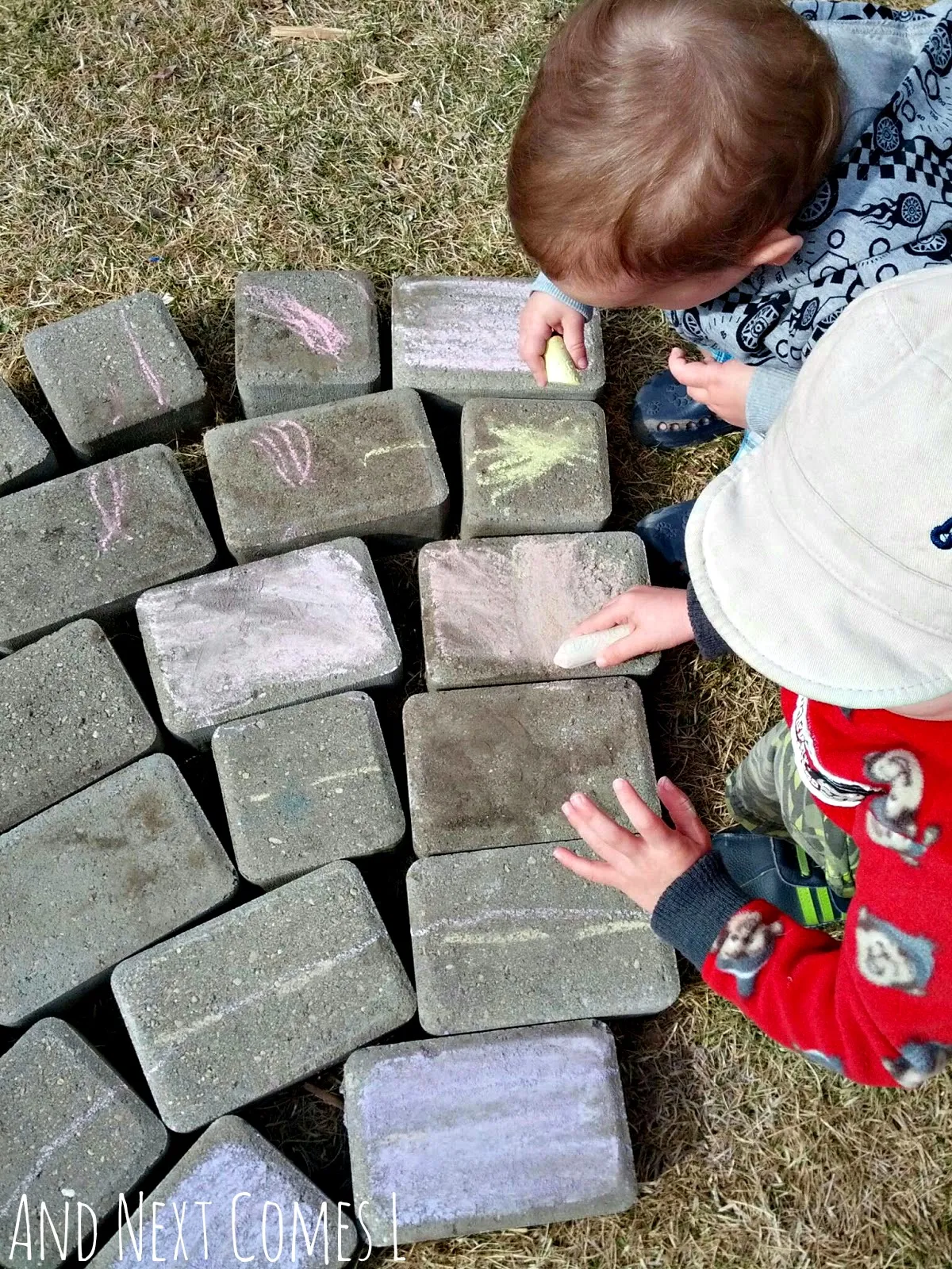 Brothers coloring paving stones with chalk to make a giant chalk rainbow from And Next Comes L