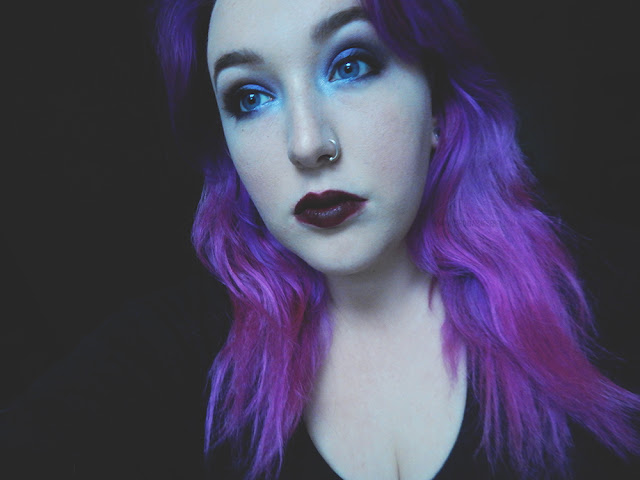 Girl with long purple hair wearing dark lipstick and dark eye makeup
