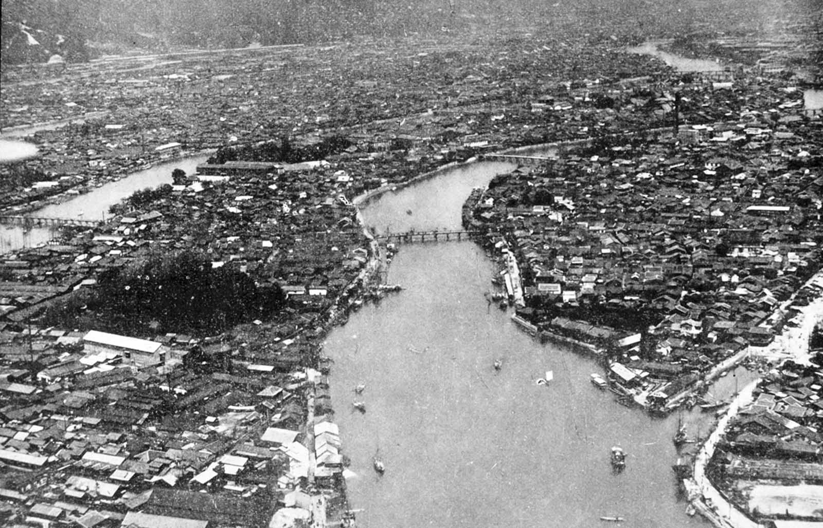 Aerial view of the densely built-up area of Hiroshima along the Motoyasugawa, looking upstream. Except for the very heavy masonry structures, the entire area was devastated. Ground zero of the atomic bomb was upper right in the photo.