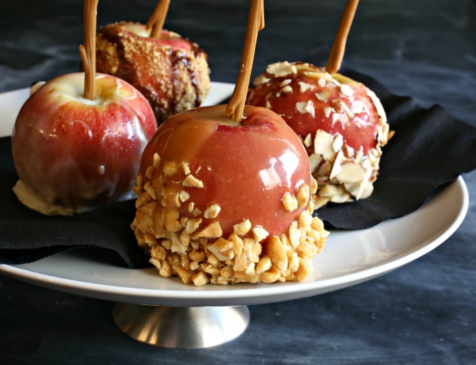 Apples dipped in tahini salted caramel and decorated with nuts and chocolate.