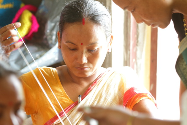 Mishing tribal woman learning the art of weaving at Panbari, Assam, India