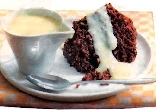 Chocolate steamed pudding slice served with custard. A classic British pudding.