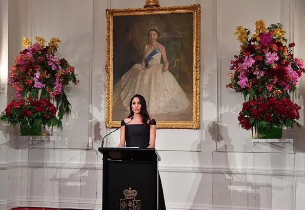 Meghan Markle wore a modified cap-sleeves navy dress by Gabriela Hearst and carried a navy leather clutch by Dior. Gabriela Hearst Navy Herve dress