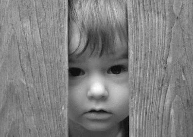 criança olhando pela fresta da porta
