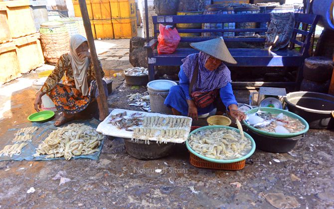 Ibu-ibu paruh baya menjual hasil laut dari nelayan