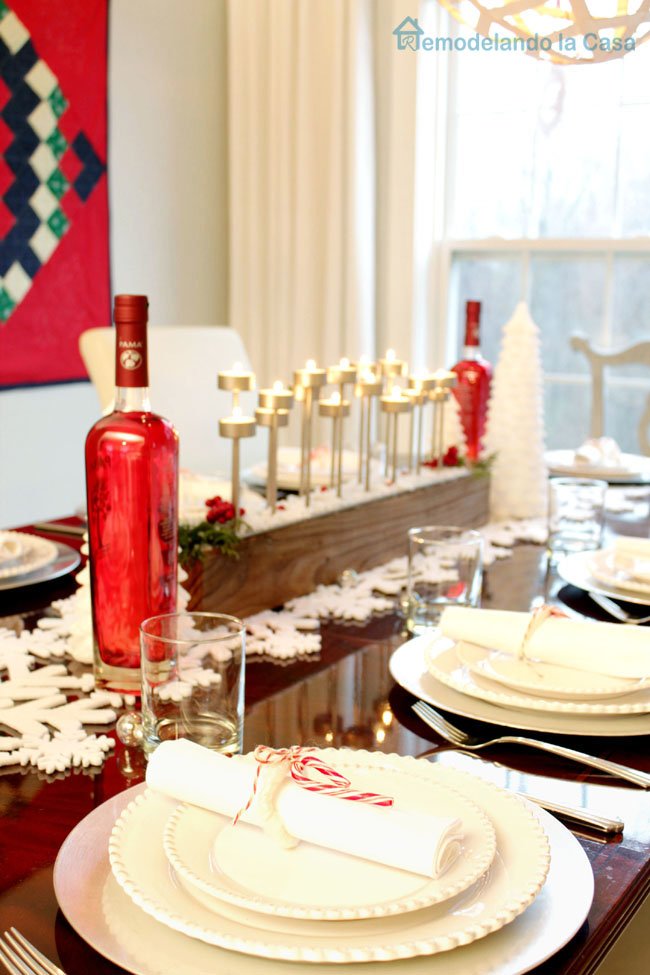 red bottles, candy cane napkin holders and candelabra on Christmas table