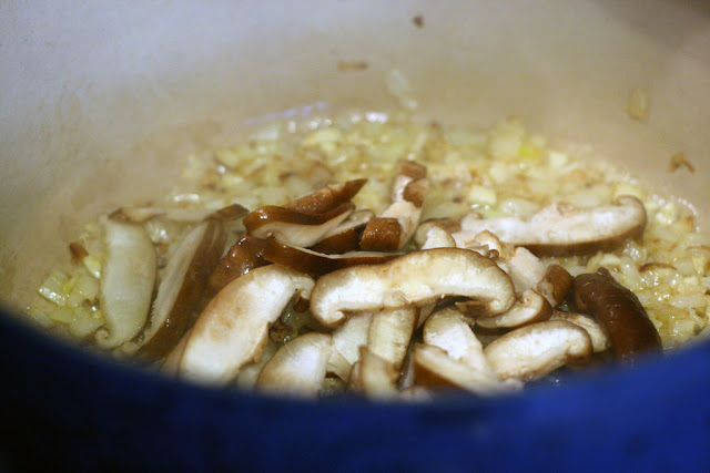 adding shiitake mushrooms to the garlic and onion mixture