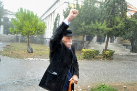 O Μανώλης Γλέζος στα 95 του,   έχει αψηφήσει την καταρρακτώδη βροχή.