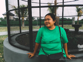 Woman Enjoy A Holiday Sitting At The Big Cage Of Bird In The Park At Badung, Bali, Indonesia