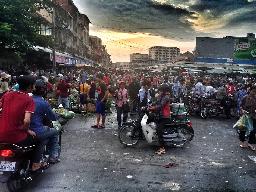 Woman in Gray and Red Jacket Riding White Motor in Crowded Place Woman in Gray and Red Jacket Riding White Motor in Crowded Place
