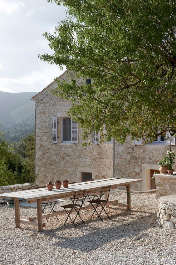 French courtyard Picture perfect farmhouse stone house with blue shutters and outdoor dining area. French Farmhouse Decor Inspiration Ideas will take you on a romantic tour of images capturing this charming decor style. #Frenchfarmhouse #frenchcountry #outdoordining #exterior #romanticdecor