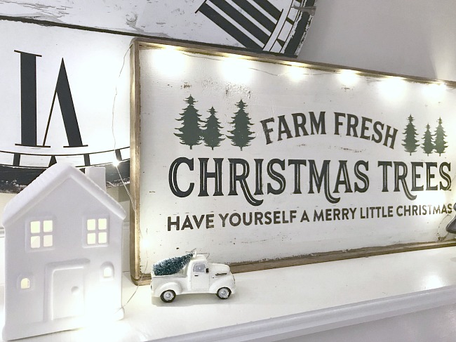 Painted christmas sign on mantel with house