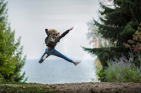 Young girl on a hike, leaping in the air, dynamic