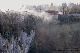 Winter chimney smoke floats above a natural stone wall and cave in Pazin Istria Croatia