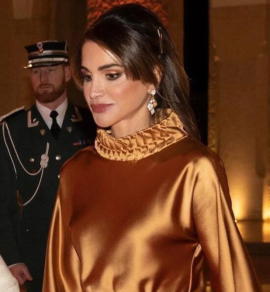 Satin blouse. Queen Sonja wore gold diamonds and emerald necklace. Queen Sonja wore gold and diamond leaf earrings.