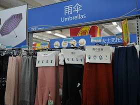 scarves on display under an "umbrellas" sign at a Walmart in Zhongshan