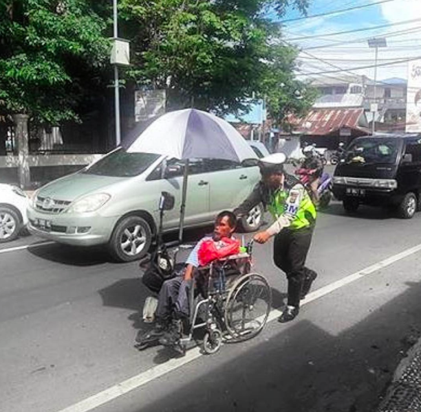 Mulia, Polisi Ini Bantu Penyandang Cacat. 'Tuhan Berkati Tugasmu Pak'