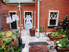 Miniature terrace house back yard with paper tape on the windows and washing on the line.