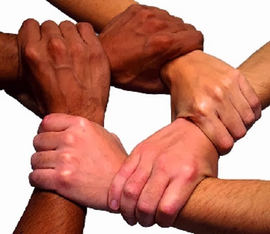 Grupo de personas diversas uniendo sus manos en un gesto de solidaridad y unidad, simbolizando la inclusión y el trabajo en equipo