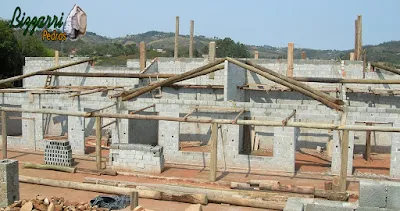 Detalhe do madeiramento com eucalipto tratado de demolição na construção rústica com a alvenaria de bloco de cimento com os pisos com cimento queimado e pisos com pedra São Tomé.