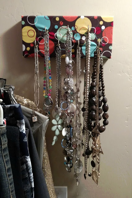 Make your own hanging necklace holder using a piece of scrap wood and some cute drawer knobs!