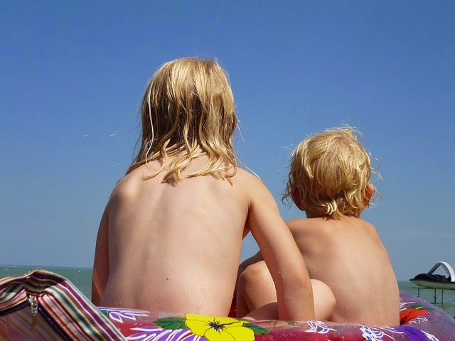 Zwei Kinder sitzen in der Sonne