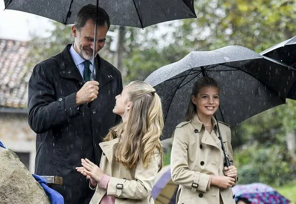 Crown Princess Leonor and Infanta Sofia wore Carolina Herrera trench coat, Mango Prince of Wales trousers. Queen Letizia