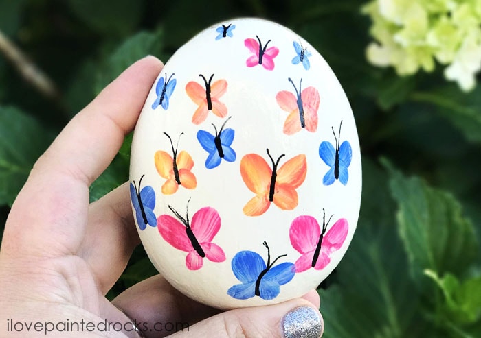 Watercolor butterfly rock painting ideas. I love this for garden art. This same technique would look great on stepping stones, too. #rockpainting #PaintedRockIdeas #paintedrocks #paintrock #paintedstone #rockart #stoneart #paintedstoneideas #ilovepaintedrocks #crafts #rockcrafts