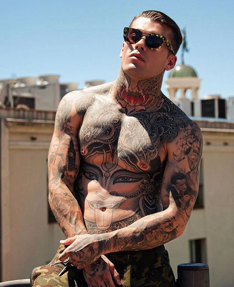 Imagen de un hombre con tatuaje de Buda en todo el torso