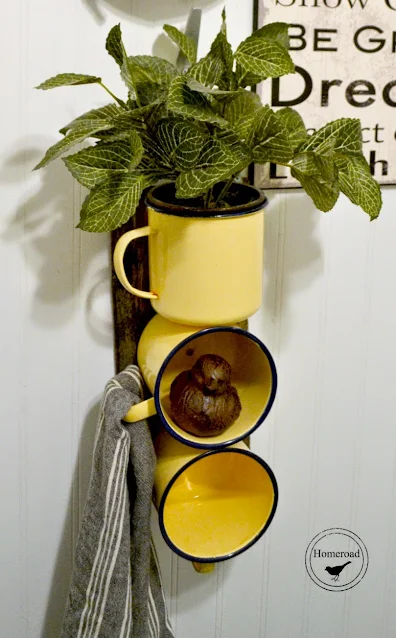 Yellow enamelware mug organizer filled with plants