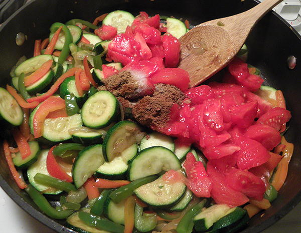 Sauteed veggies with tomatoes and spices added
