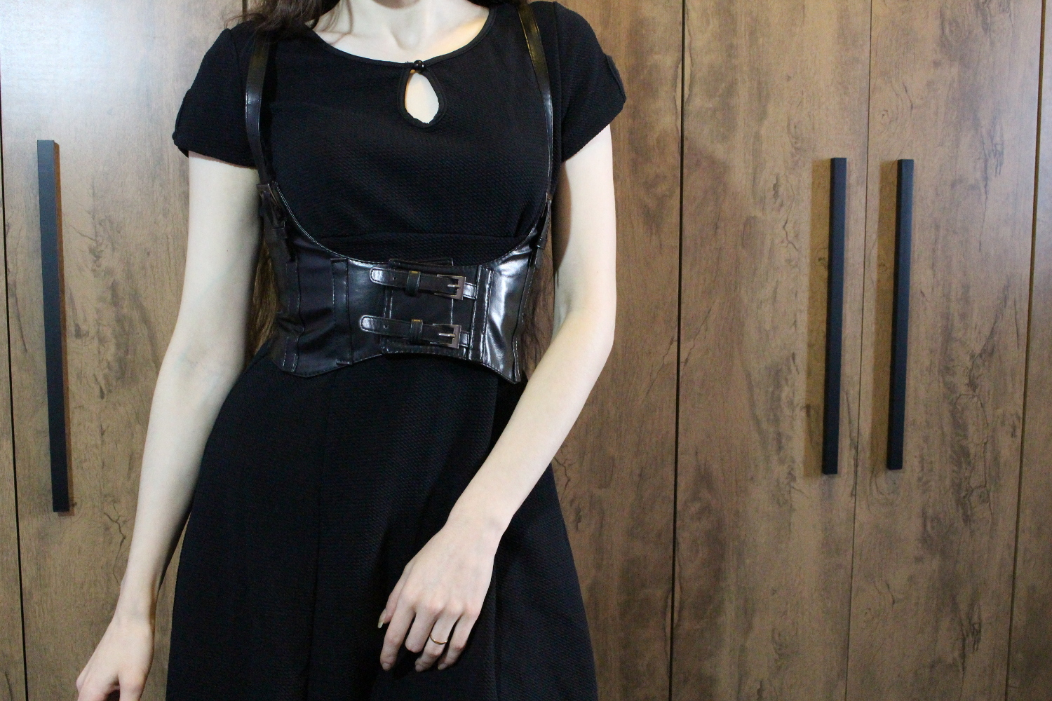 blogger Liz Breygel demonstrates a simple, everyday gothic outfit with a corset belt and black vintage-loooking dress