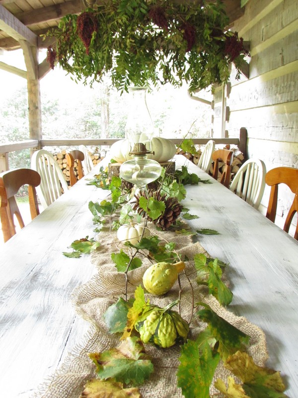 Outdoor Fall Tablescape featuring white pumpkins, outdoor chandelier, antique glass lamps
