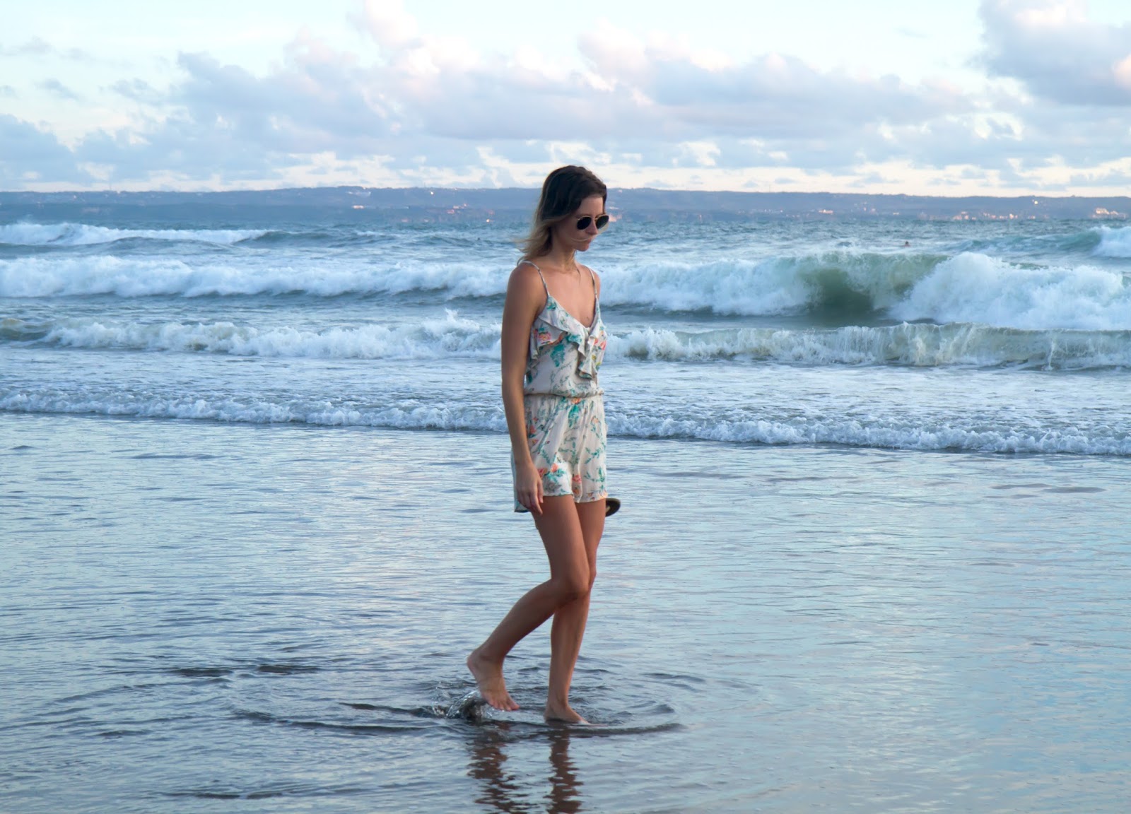 fashion and travel blogger, Alison Hutchinson, is wearing a Billabong Romper on the beach in Bali