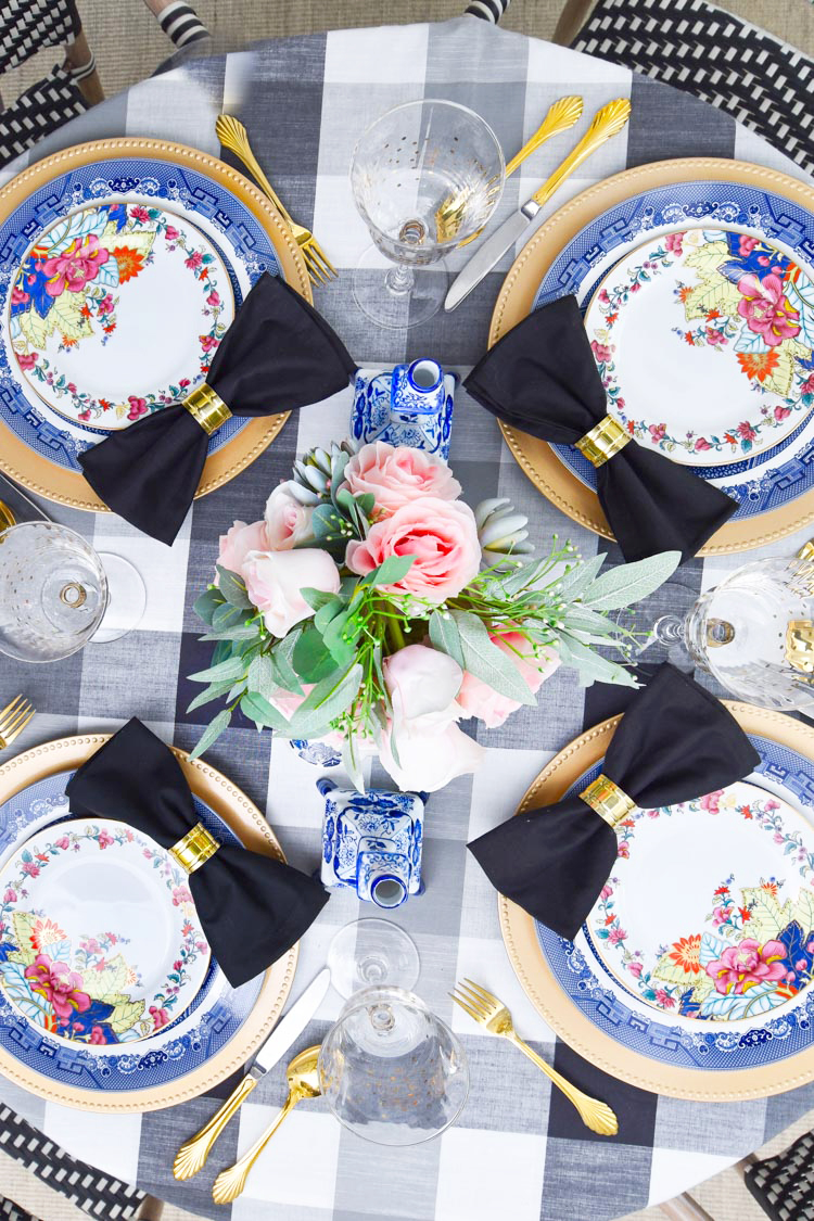 Bold and glam imperial leaf and tobacco leaf china paired with blue and white blue willow dinner plates and a floral centerpiece. Chinoiserie chic tablescape and centerpiece. #diningroom #diningroomdecor #chinoiserie #asiandecor #entertaining