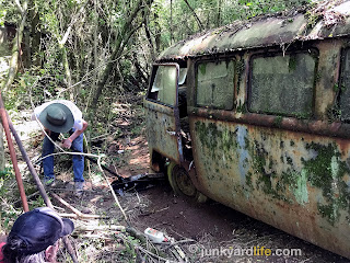 My son works on digging out the 1965 VW bus' front wheel.