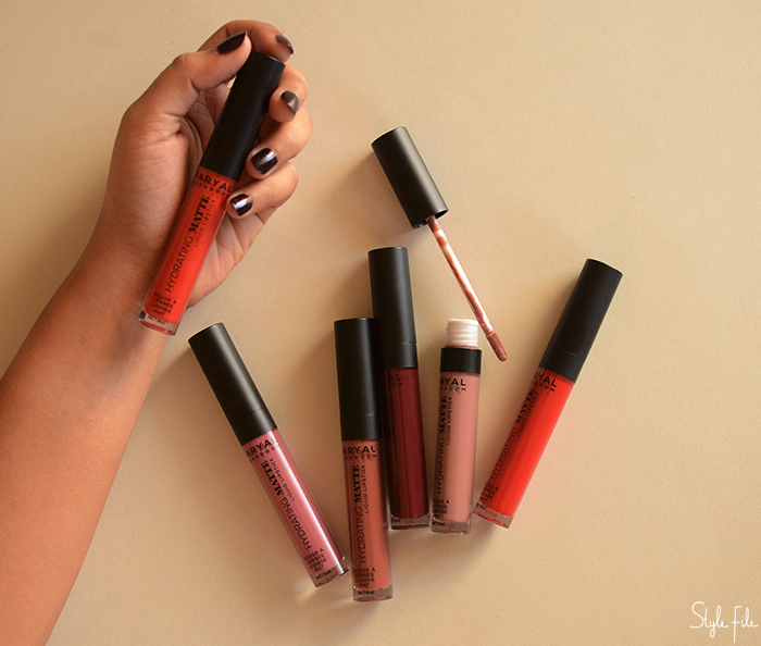 An image of 6 liquid lipsticks lip colours by Faryal Makdoom being held by a female with long dark nails