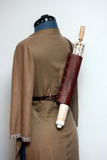 A leather parasol holder that keeps your umbrella strapped to your back like a weapon. Steampunk leather accessories for men and women for LARP and cosplay.
