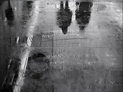 reflexia siluetelor a doi oameni pe strada uda, noaptea