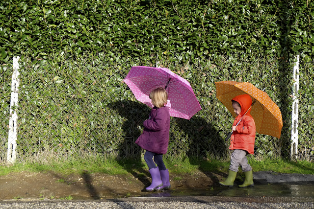 Fotografia di due bambini con ombrelli colorati