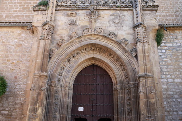Gran puerta de iglesia antigua europea de madera y piedra con adornos.
