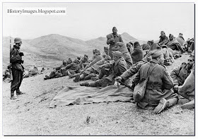 Rare WW2 Images Greek soldiers taken prisoner sit around  German guard watches 