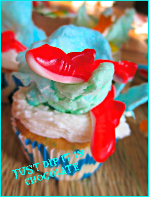 Shark Week "Sharknado" Cupcakes Recipe, Shark Week will never be the same after you take a bite our of these fun cupcakes, Filled with a "Bloody" delicious raspberry filling they are great for a creepy Luau, a Halloween Hawaiian Gathering or just plain fun!