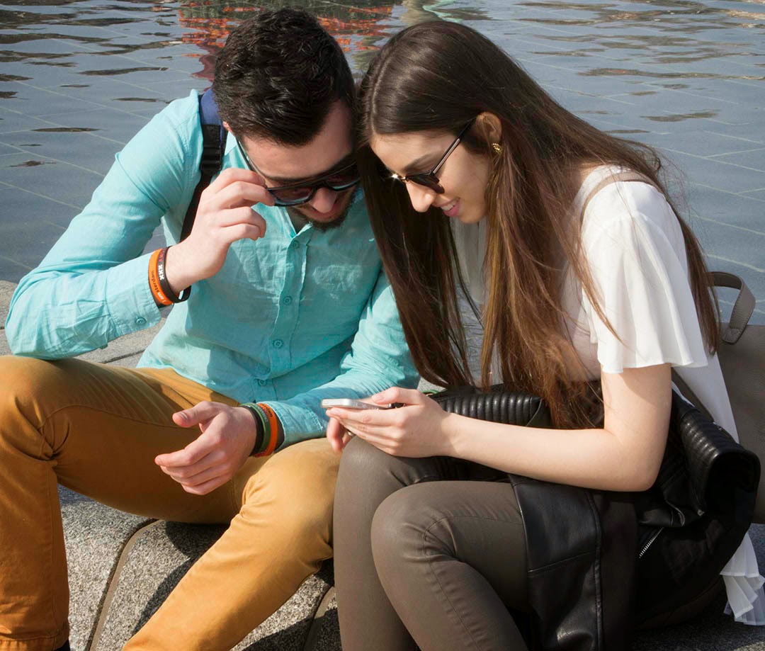 young couple looking at photo on cell phone